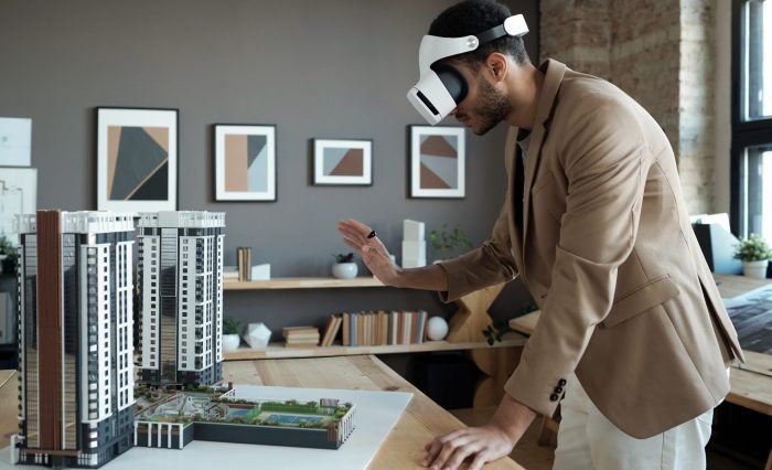 Young elegant architect standing by table with house layout during presentation best colleges for civil engineering in Coimbatore